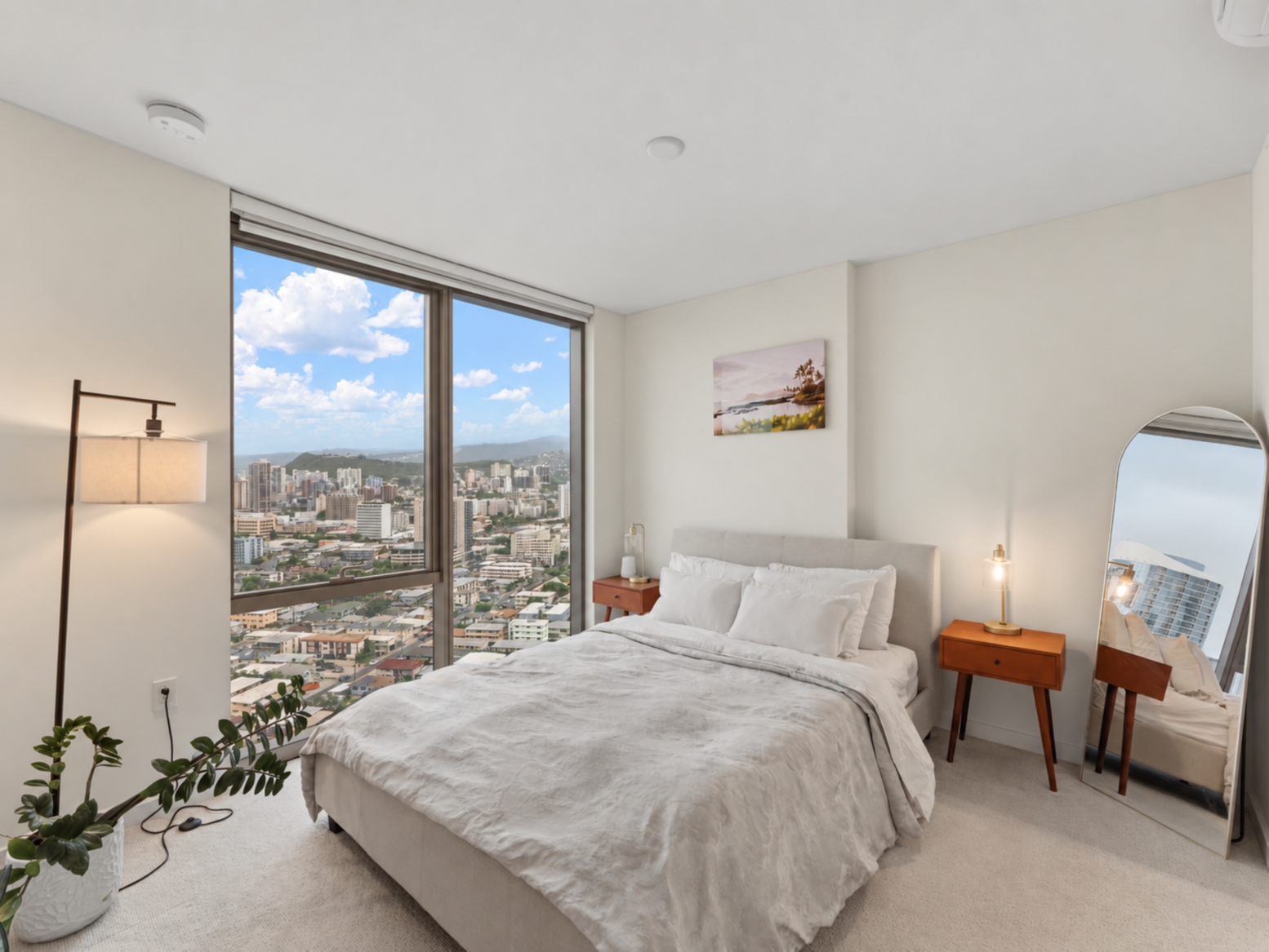Primary bedroom with king bed, floor lamp, and panoramic city views