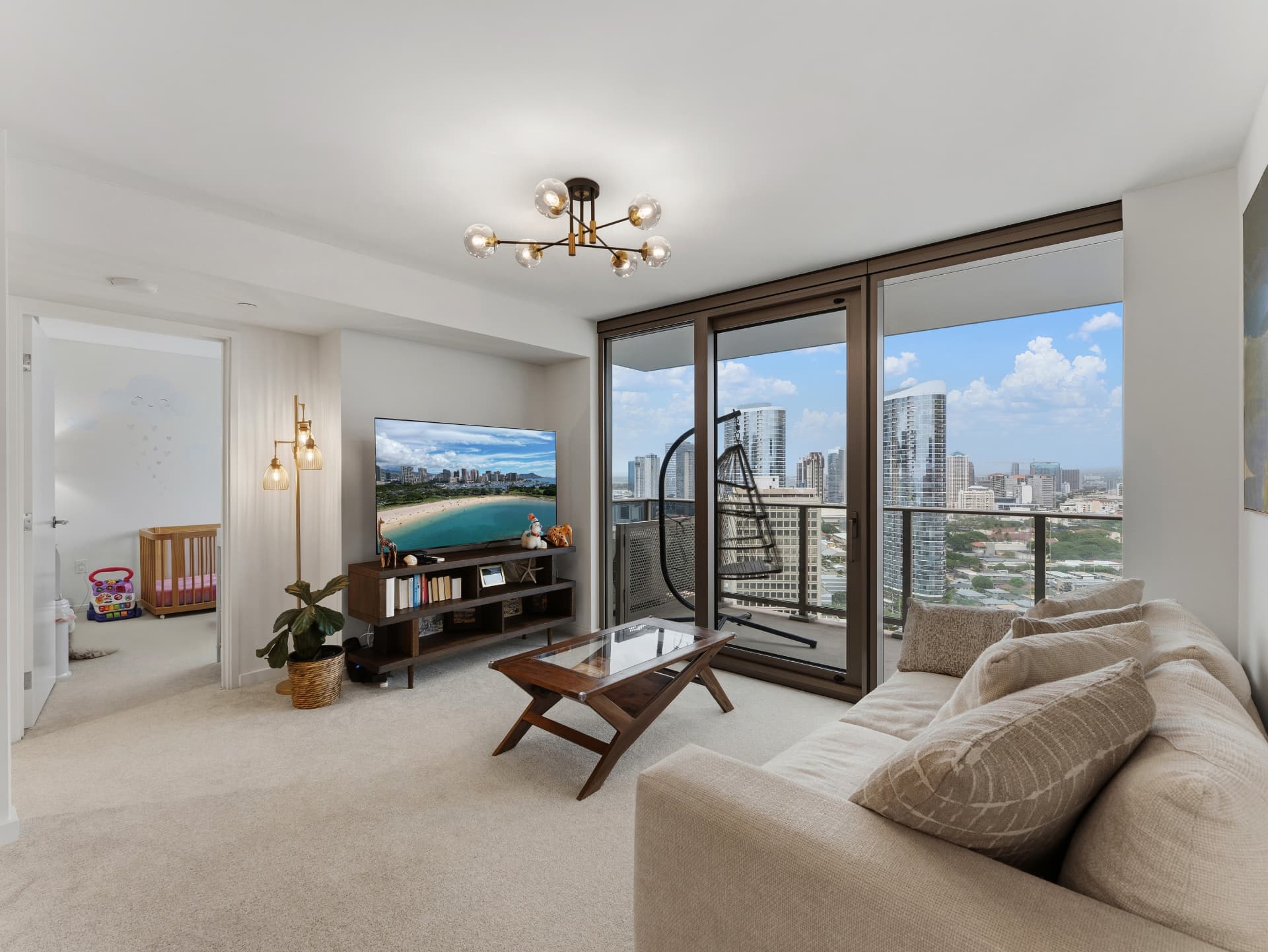 Living room with balcony swing chair and city skyline at Sky Ala Moana West unit 2806